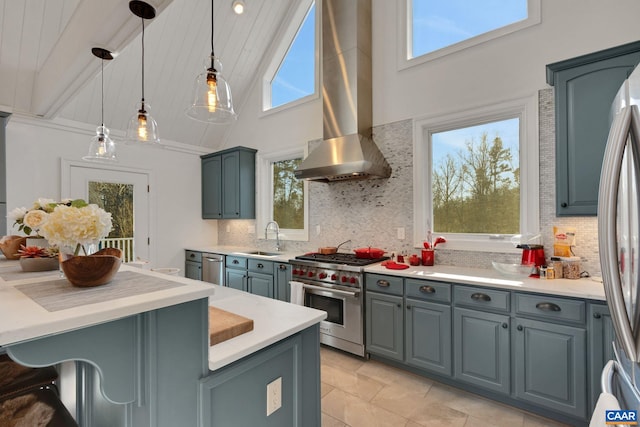 kitchen featuring sink, appliances with stainless steel finishes, tasteful backsplash, decorative light fixtures, and wall chimney exhaust hood