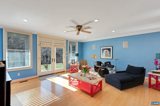 living room with french doors, ceiling fan, crown molding, and light hardwood / wood-style floors