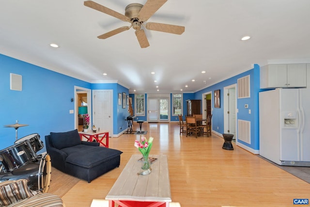 living room with ornamental molding, ceiling fan, and light hardwood / wood-style flooring