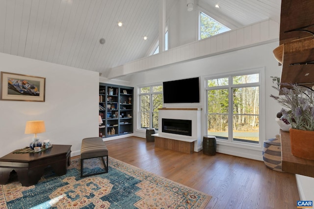 living room featuring wood-type flooring, a healthy amount of sunlight, wooden ceiling, and high vaulted ceiling