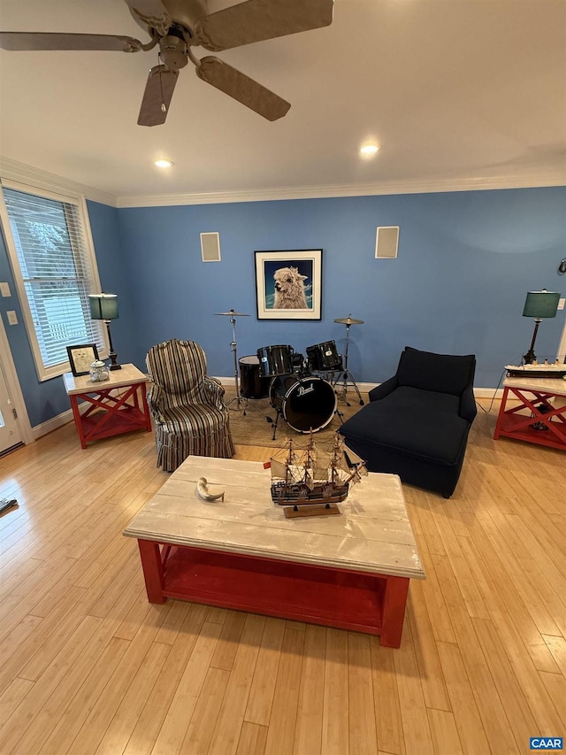 living room featuring crown molding, light hardwood / wood-style flooring, and ceiling fan