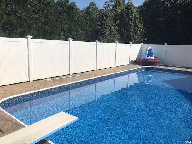 view of swimming pool with a diving board