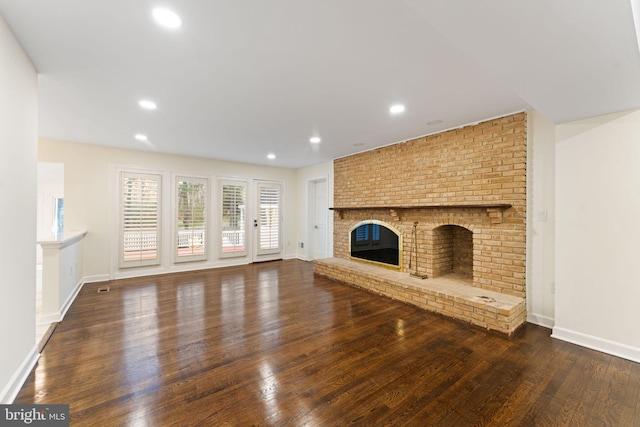 unfurnished living room featuring baseboards, a fireplace, wood finished floors, and recessed lighting