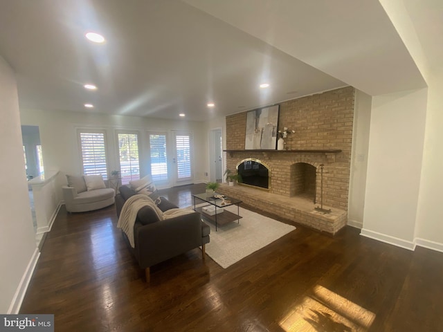 living room with a brick fireplace, baseboards, dark wood finished floors, and recessed lighting