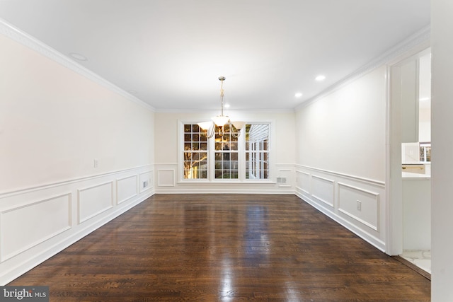 unfurnished dining area with ornamental molding, dark wood-style flooring, a notable chandelier, and a decorative wall