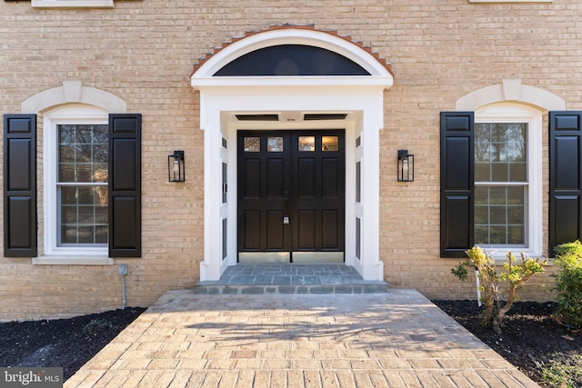 doorway to property featuring brick siding