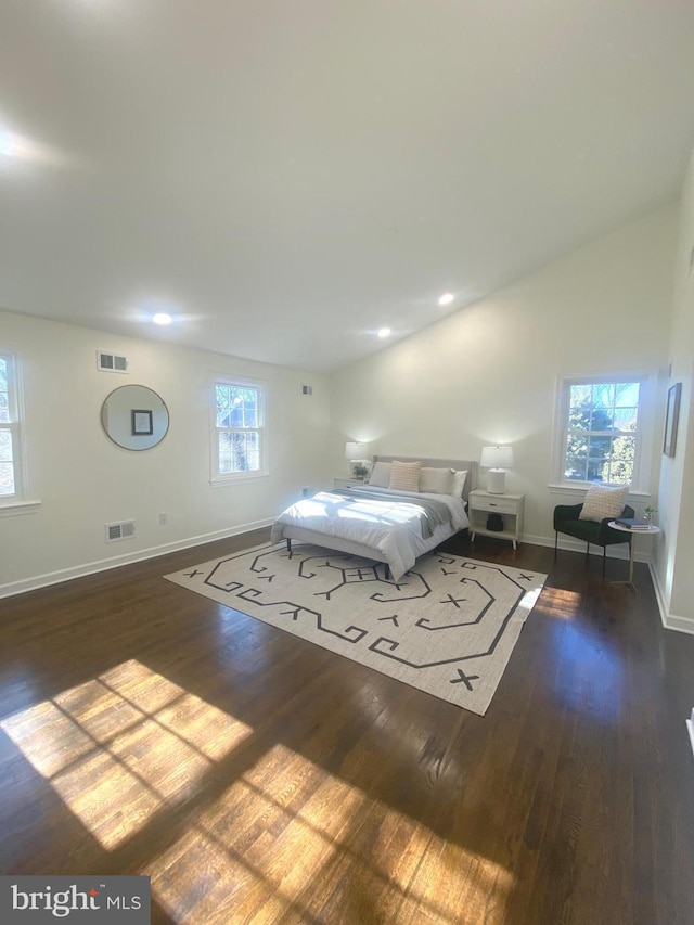 unfurnished bedroom featuring baseboards, visible vents, vaulted ceiling, and dark wood-type flooring