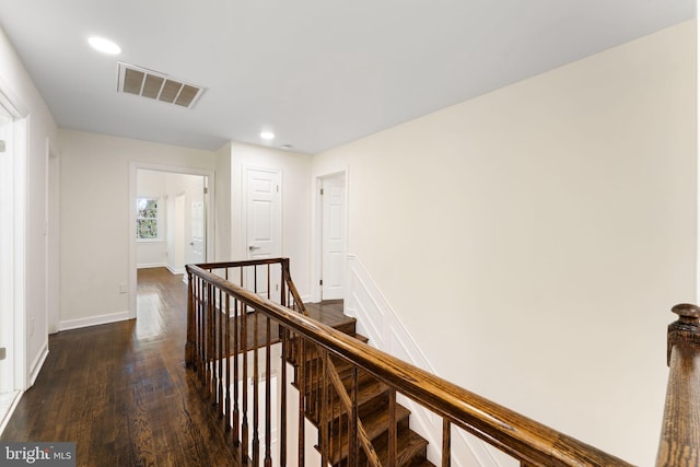 corridor with visible vents, baseboards, dark wood-style floors, an upstairs landing, and recessed lighting