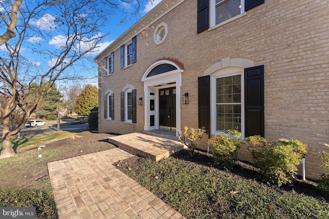 doorway to property with brick siding