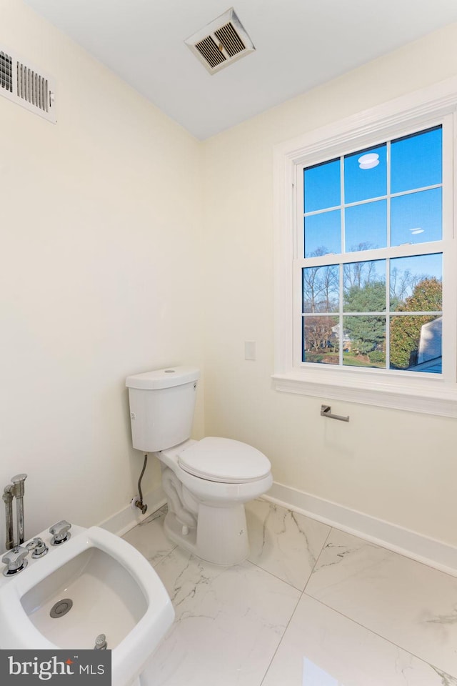 bathroom with marble finish floor, baseboards, visible vents, and a bidet