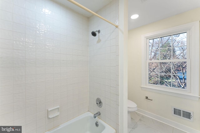 bathroom featuring baseboards, visible vents, toilet, marble finish floor, and shower / washtub combination