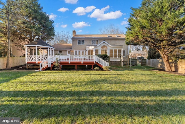 rear view of property featuring a fenced backyard, a yard, stairway, and a wooden deck