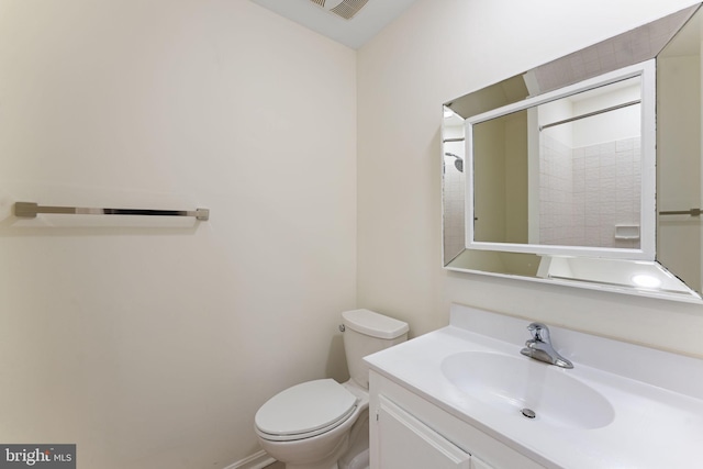 bathroom with toilet, visible vents, vanity, and a shower with door