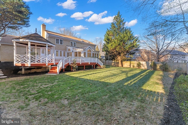 rear view of house featuring a lawn, a fenced backyard, a chimney, a wooden deck, and a pergola