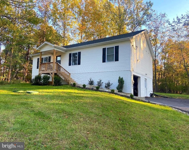 view of front of home featuring a garage, a front yard, and covered porch