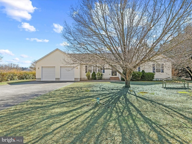 ranch-style home with a front yard, driveway, an attached garage, and entry steps