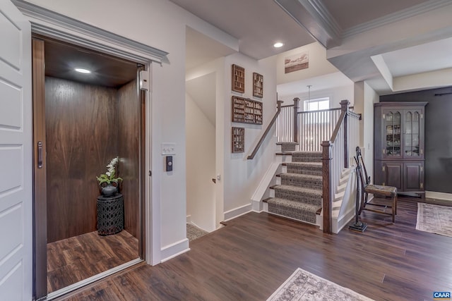 foyer entrance featuring elevator, crown molding, and dark hardwood / wood-style floors