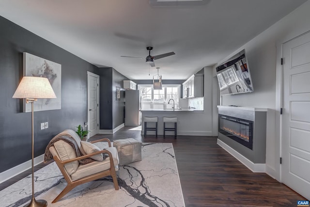 living room featuring ceiling fan, dark hardwood / wood-style flooring, and sink