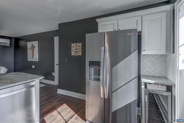 kitchen featuring appliances with stainless steel finishes, white cabinetry, wine cooler, a wall mounted air conditioner, and tasteful backsplash