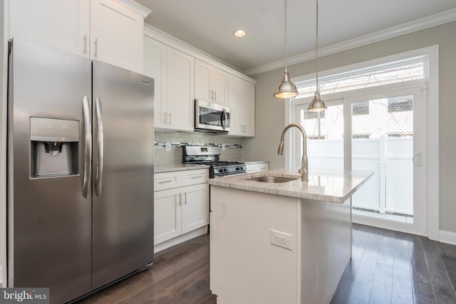 kitchen featuring stainless steel appliances, sink, a center island with sink, and white cabinets