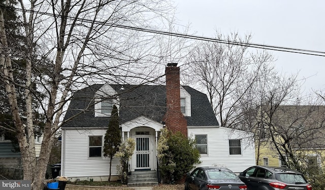 view of front of house featuring a chimney and a shingled roof