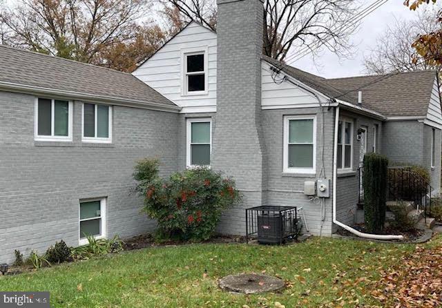 view of side of home featuring a yard and cooling unit