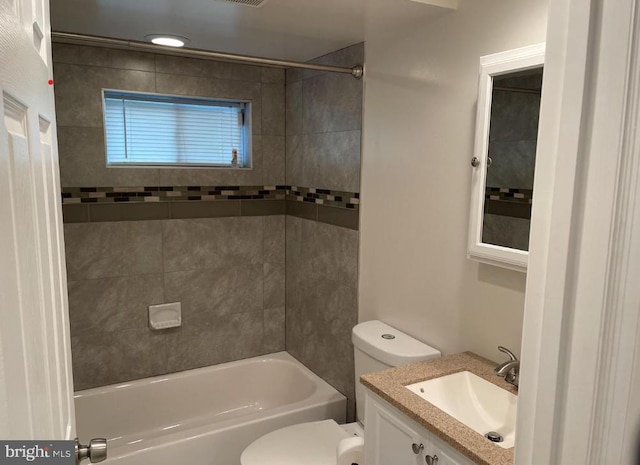 full bathroom featuring tiled shower / bath combo, vanity, and toilet