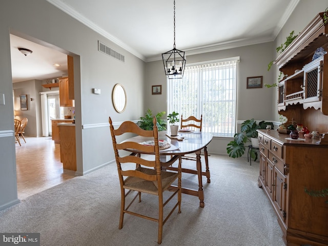 carpeted dining area featuring ornamental molding and a chandelier