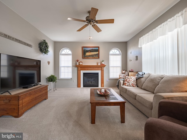 living room with a healthy amount of sunlight, ceiling fan, and light colored carpet