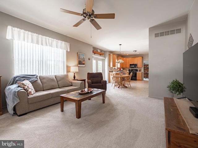 carpeted living room featuring ceiling fan