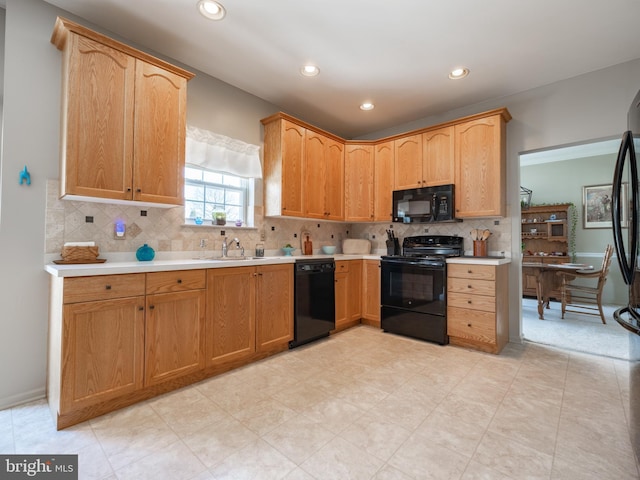 kitchen with sink, black appliances, and backsplash