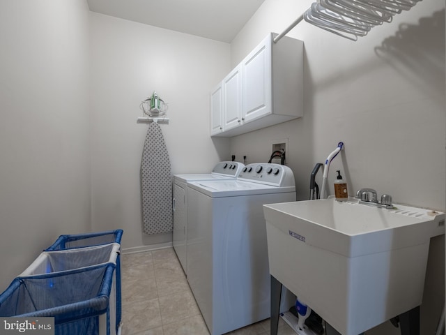 laundry area featuring light tile patterned flooring, cabinets, sink, and washing machine and clothes dryer