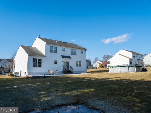 back of property featuring a covered pool, a patio area, central air condition unit, and a yard