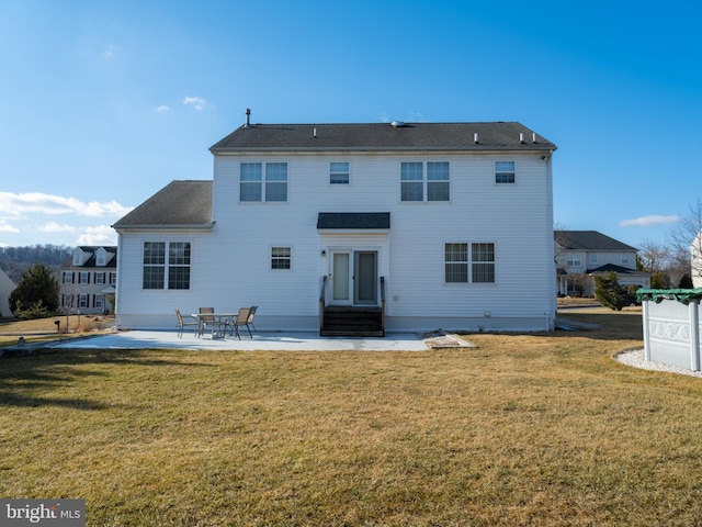 rear view of house with a patio and a lawn