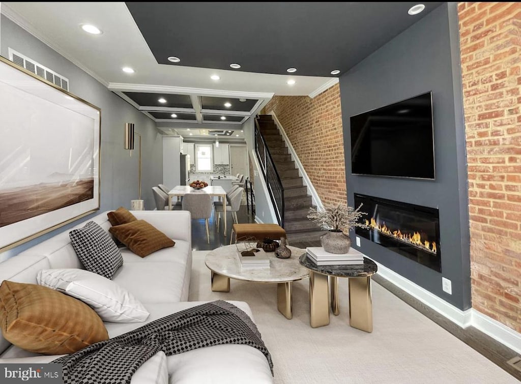 interior space featuring coffered ceiling, beam ceiling, ornamental molding, and brick wall