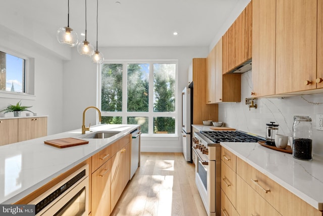 kitchen featuring pendant lighting, sink, decorative backsplash, light stone countertops, and white appliances