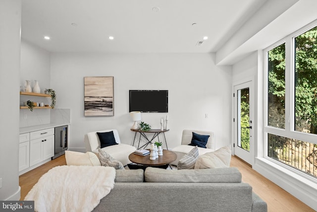 living room with wine cooler and light hardwood / wood-style flooring