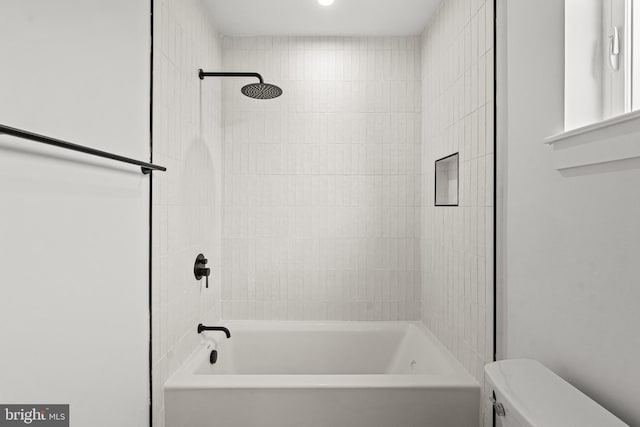 bathroom featuring toilet and tiled shower / bath combo