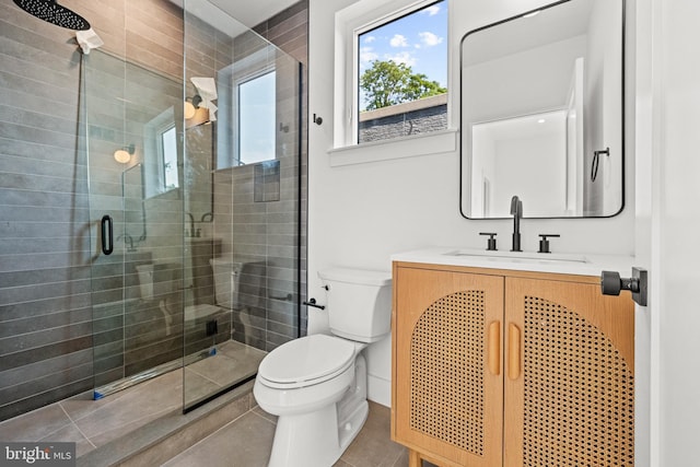 bathroom featuring a shower with door, vanity, tile patterned floors, and toilet