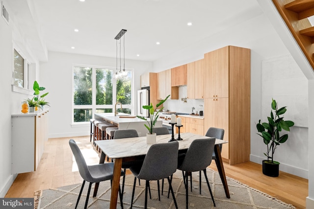 dining space featuring sink and light hardwood / wood-style floors