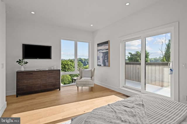 bedroom featuring access to exterior and light wood-type flooring