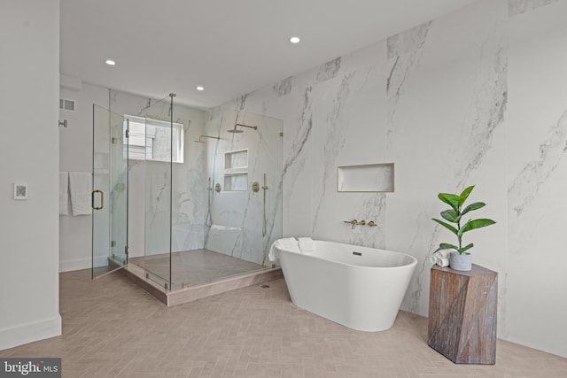 bathroom featuring tile walls and separate shower and tub