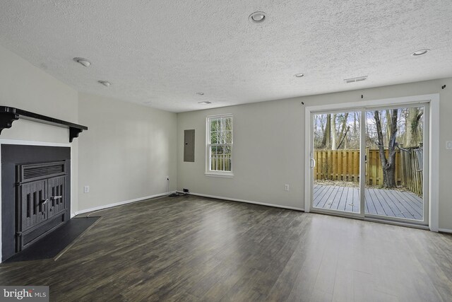 unfurnished living room with electric panel, baseboards, a fireplace, and wood finished floors