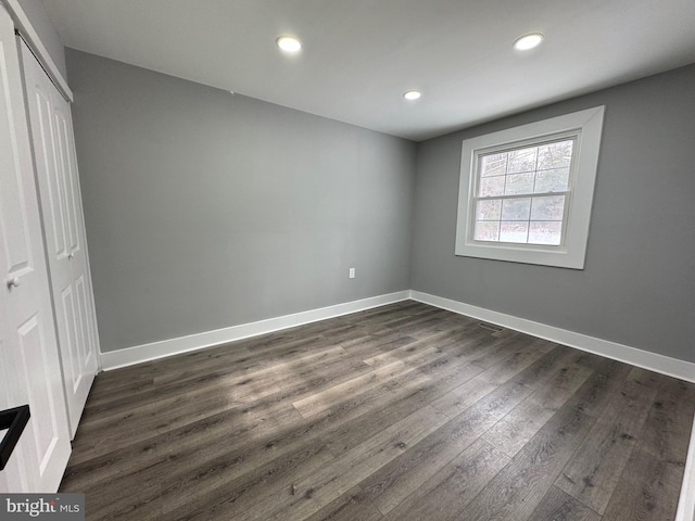 unfurnished bedroom with a closet and dark hardwood / wood-style flooring