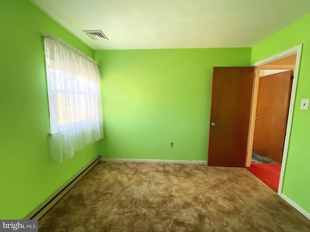 spare room with baseboard heating and carpet