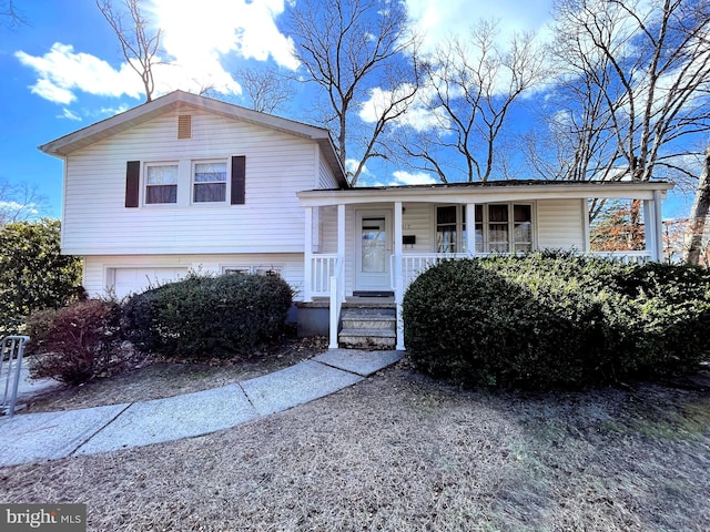 split level home featuring a garage and a porch