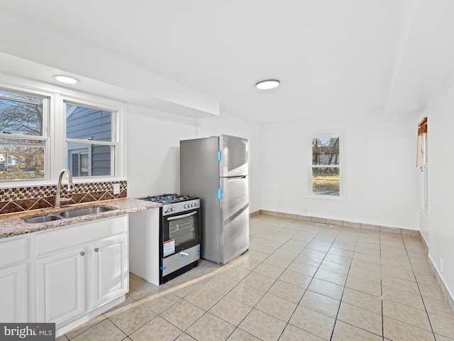 kitchen with white cabinetry, appliances with stainless steel finishes, sink, and light tile patterned flooring