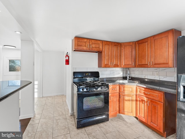 kitchen with sink, black gas range, and decorative backsplash