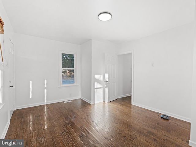 empty room with dark hardwood / wood-style floors