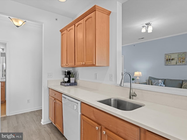 kitchen with a sink, light wood-style flooring, light countertops, and dishwasher